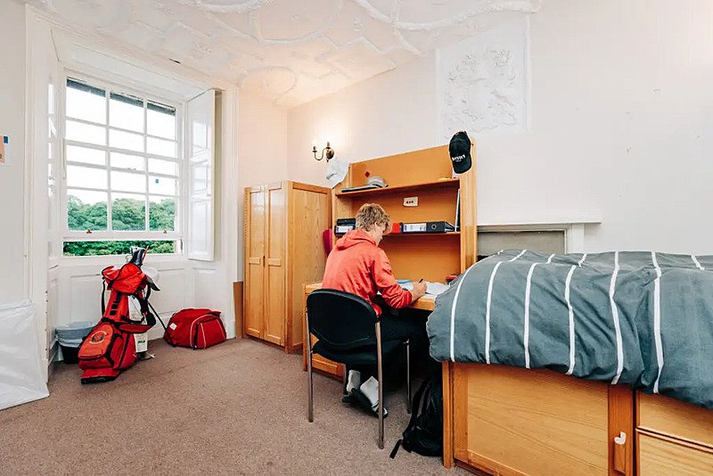 A student learning at his desk in his single boarding room at Loretto School