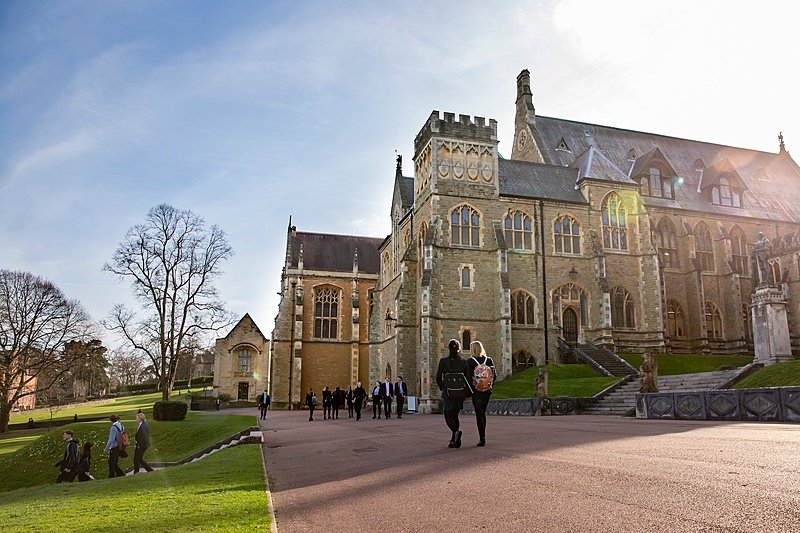 Students walking over the school campus at Malvern College in the spring sunshine