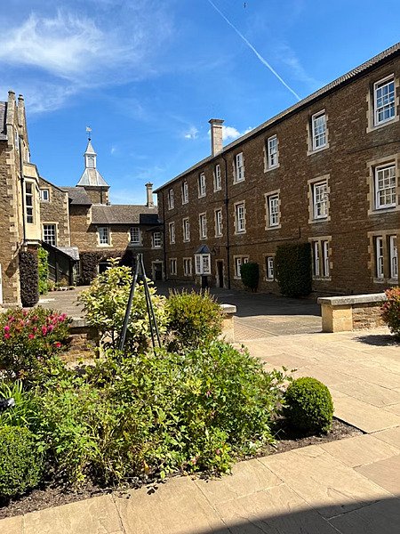 School courtyard, brown brickstone houses, little tower in the background
