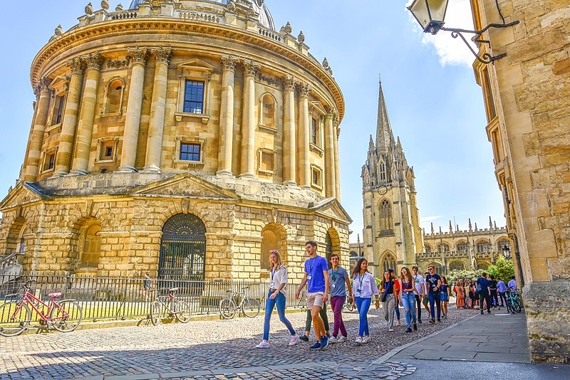 a group of visitors between the impressive buildings on a trip to Oxford
