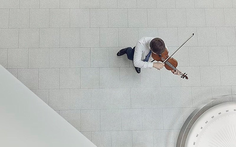A student playing the violin, seen from above