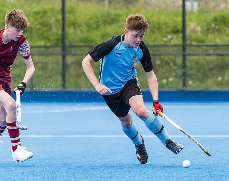 two boys in action on the hockey pitch