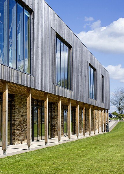Modern art building with wood-panelled top floor and large ceiling and stone walled bottom floor